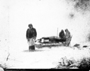 Image of Two men by upstanders; 1 on snowshoes